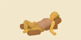 Restorative Yoga – vrouw in ondersteunde liggende houding met bolsters en dekens voor herstel en diepe ontspanning